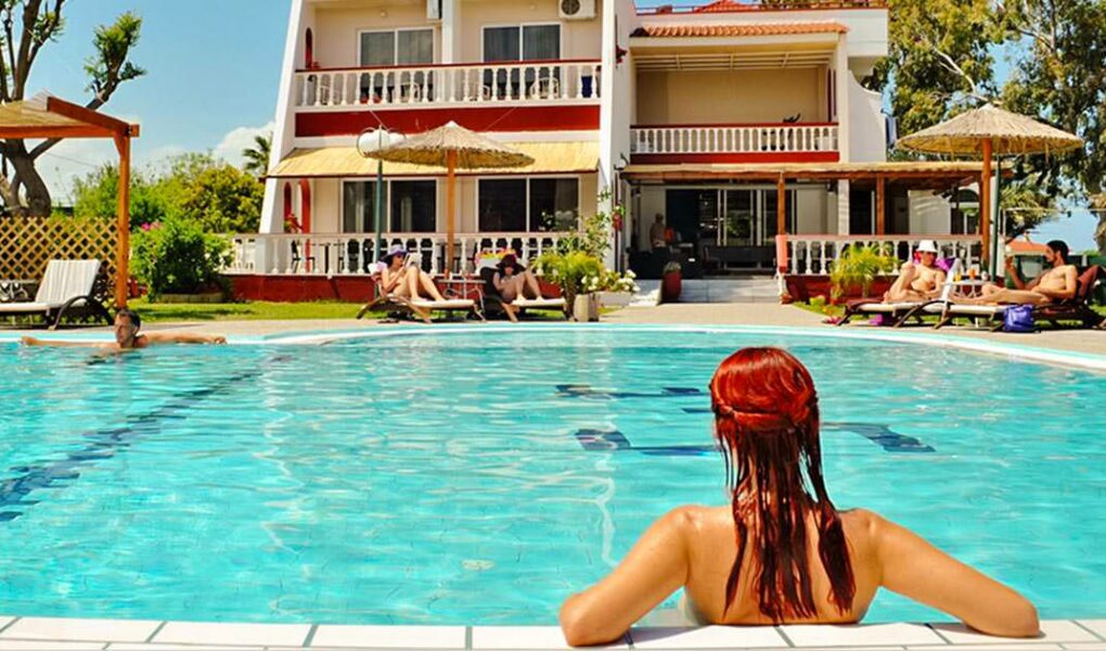 Nude visitors relaxing in and around the swimming pool at Naturist Angel Club Hotel in Rhodes, one of the best clothing-optional resorts in Greece
