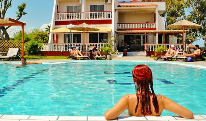 Nude visitors relaxing in and around the swimming pool at Naturist Angel Club Hotel in Rhodes, one of the best clothing-optional resorts in Greece