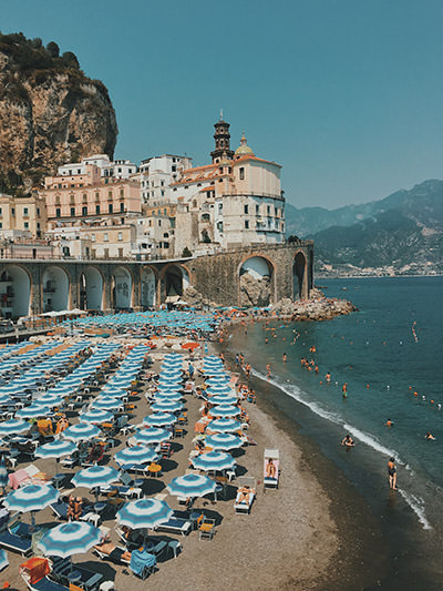 Parasols on the beach in Atrani, one of the towns on Amalfi Coast in Italy, the world's best electric car road trip, photo by Nellia Kurme, Unsplash