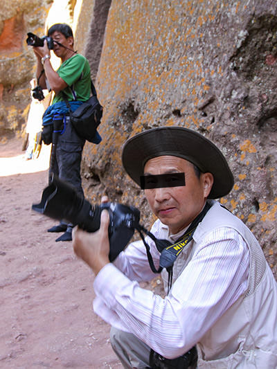 The unhappy face of a Chinese photographer after he was obsessively taking photographs of churchgoers at Bete Giyorgis church in Lalibela, Ethiopia, and then caught on camera of Pipeaway blogger Ivan Kralj who decided to "fight fire with fire", and turned the lens toward the perpetrator
