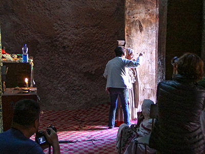 Chinese woman instructing an Ethiopian woman how to pose and where to look for the photography needs of her and her colleagues, at Bete Giyorgis, church in Lalibela, Ethiopia, photo by Ivan Kralj