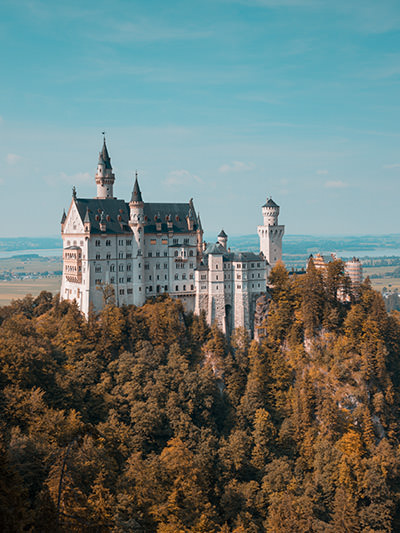Neuschwanstein Castle on the hilltop, one of the road stops on the Romantic Road, part of the best electric car road trip in Germany, photo by Eric Marty, Unsplash