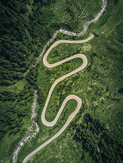 Hairpin turns and entrance to the tunnel in the verdant surrounding - Transfagarasan in Romania is one of the best destinations for an electric car road trip, photo by Jaromir Kavan, Unsplash