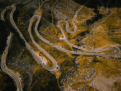 Aerial view of hairpin turns of serpentine Transfagarasan road in Romania, photo by Umit Yildirim, Unsplash