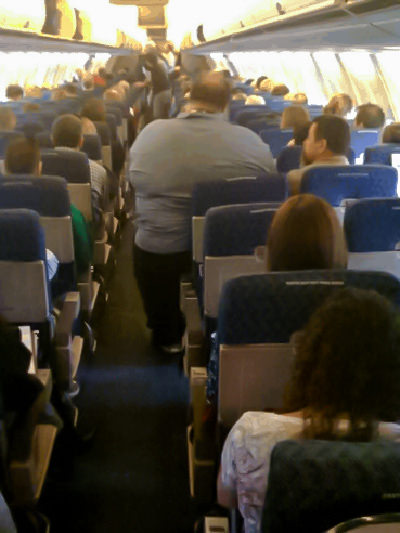 Obese passenger on a plane of American Airlines, spilling out of his seat into the aisle, viral photo allegedly snapped by the airline's flight attendant