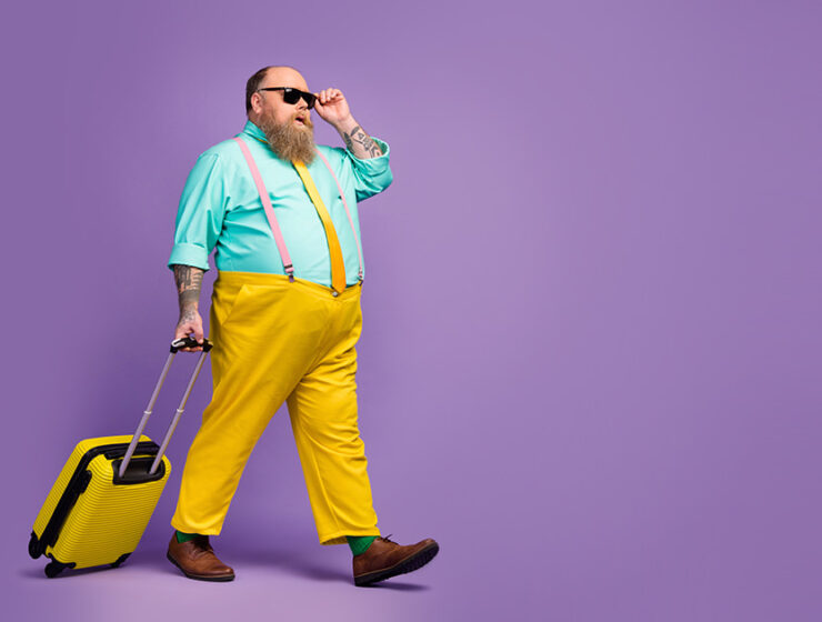 Colorfully dressed obese passenger in sunglasses walking to his plane with a wheeled yellow bag, photo by deagreez1, Depositphotos