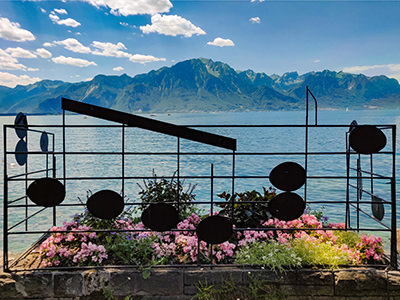 Fence with musical notes decoration at the banks of Lake Geneva in Montreux, Switzerland, with French Alps in the background, photo by Ivan Kralj.