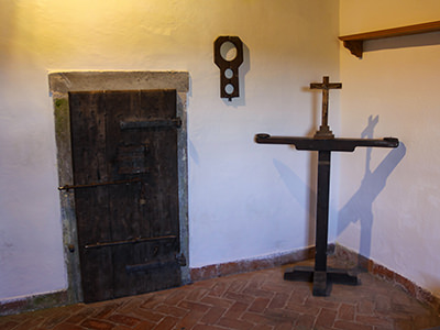 Prison doors and a wooden cross in the courtroom of Predjama Castle, Slovenia, photo by Ivan Kralj.