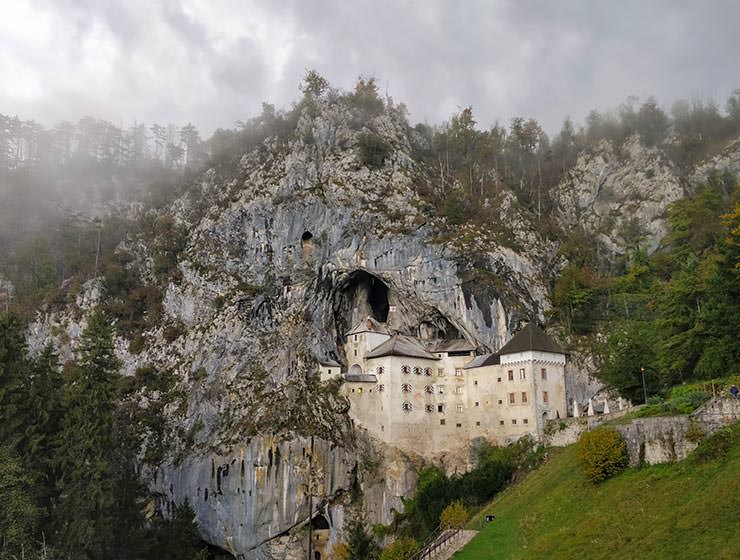 Predjama Castle in Slovenia, the largest cave castle in the world, wrapped in mountain and fog, photo by Ivan Kralj.