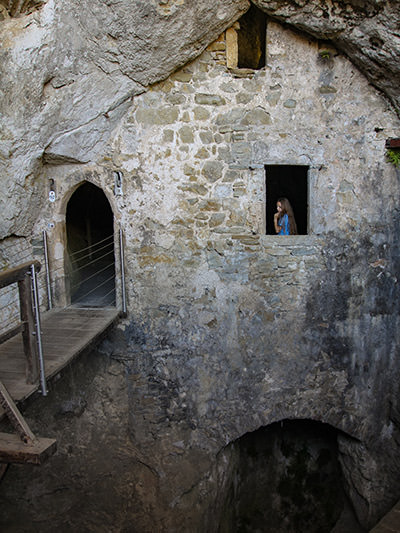 Inner section of Predjama Castle with a girl visitor on one of the windows, Slovenia, photo by Ivan Kralj.