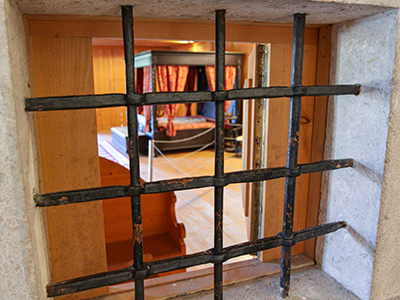 The view of the master bedroom through the bars of the window in the chapel inside Predjama Castle, Slovenia, photo by Ivan Kralj.