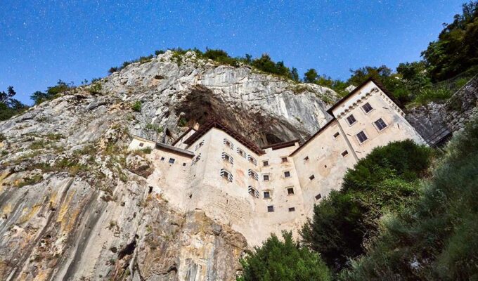Predjama Castle exterior, embraced by the mountain, from a frog's-eye view, credit: Postojna Cave Park, Slovenia.