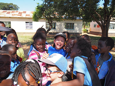 Canadian children encircled by newfound friends in Africa, photo by Edith Lemay
