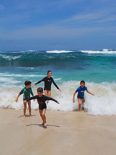 Edith Lemay's children playing with the waves on the beach during their world trip before they lose their vision, photo by Edith Lemay