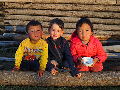 Laurent, a Canadian boy posing with newfound friends in Mongolia, on his family's world trip to fill his visual memory before going blind, photo by Edith Lemay