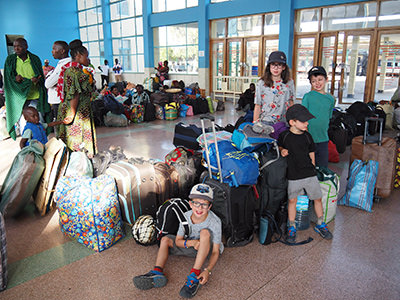 Canadian children in African train station with luggage, photo by Edith Lemay
