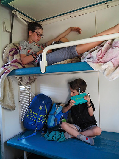 Edith Lemay children reading e-books and listening to audio books during a train ride in Africa, photo by Edith Lemay