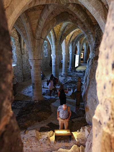 Tourists exploring the cathedral-resembling dungeon in Chillon Castle, Switzerland, photo by Ivan Kralj.