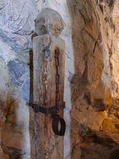 Wooden pillar with a chain for the prisoner in Chillon Castle dungeon, Switzerland, photo by Ivan Kralj.