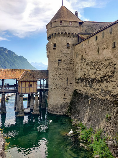 Chillon Castle on Lake Geneva, Switzerland, connected to the shore with a wooden bridge, photo by Ivan Kralj.