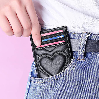 Woman putting a card-holder wallet with quilted heart into her pocket, a perfect Valentine's Day gift for her, by Auner Leather.