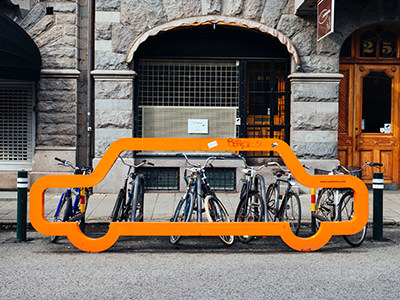 Bike parking in Malmö, Sweden, on a rack with an outline of a car, photo by Susan Q Yin, Unsplash.