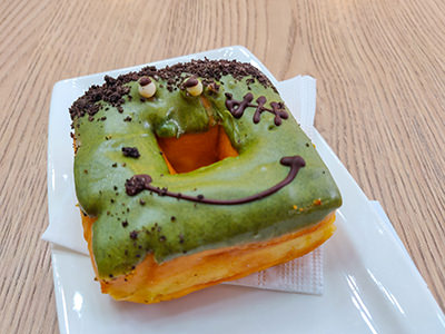Matcha donut in a square shape resembling Frankenstein's face, made for Halloween at The Box Donut, an innovative donut shop in Budapest, Hungary, photo by Ivan Kralj.