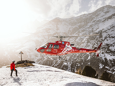 Helicopter flying over snow-covered mountain in Zermatt, Switzerland, photo by Kevin Schmid, Unsplash.