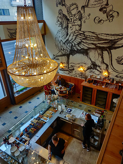 Large chandelier above the cake display in Auguszt Cukraszda, one of the best dessert places in Budapest, Hungary, photo by Ivan Kralj.