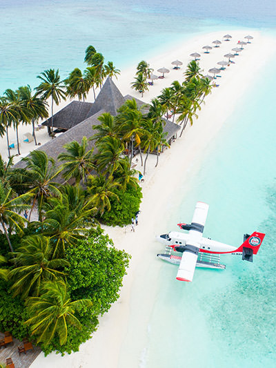 Seaplane parked in the water, at a sandy beach of Veligandu island in the Maldives, photo by Shifaaz Shamoon, Unsplash.