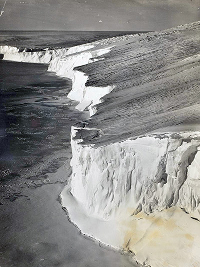 Coastal ice cliff at Adélie Land, shot during the British, Australian, New Zealand Antarctic Research Expedition 1929-1931, copyright National Archives of Australia.