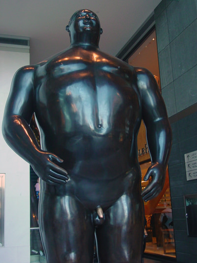 Fernando Botero's statue of Adam at Columbus Circle shopping center in New York, with a penis that changed the color due to statue rubbing by visitors believing the ritual brings them good luck; photo by Amalthya.