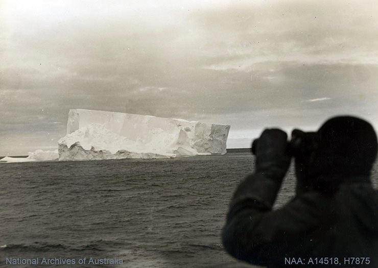 Man observing a tabular iceberg in Antarctica 1906-1937.