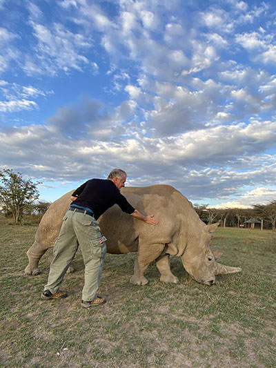 Slovenian photographer Matjaž Krivic caressing Najin, one of the last remaining norther white rhinos in the world, at Ol Pejeta Conservancy in Nanyuki, Kenya.