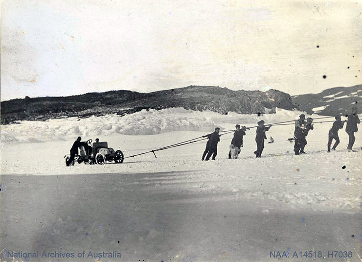 Men pulling car over ice during the British Antarctic Expedition 1907-1909.
