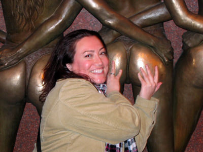 Woman posing with a smile while rubbing the butt cheeks of one of the Crazy Girls famous statue in Las Vegas, that supposedly brings good luck; photo by Bloody Marty Mix.