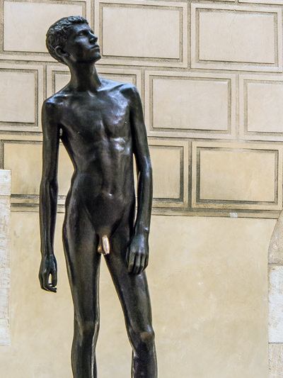 Youth statue of Miloš Zet presenting a young naked man in Prague. His penis has turned gold from interaction with hands of the passersbys who believe that statue rubbing would bring them good luck; photo by Anguskirk.