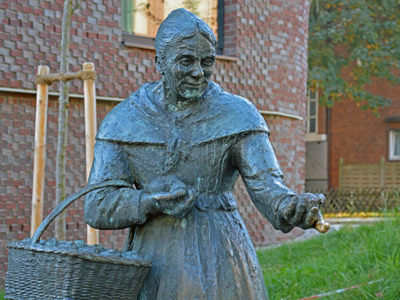 Statue of Zitronenjette, a famous Hamburg character that was selling lemons; the statue's finger has been rubbed to golden shine by passersby believing it would bring them good luck; photo by Illustratedjc.