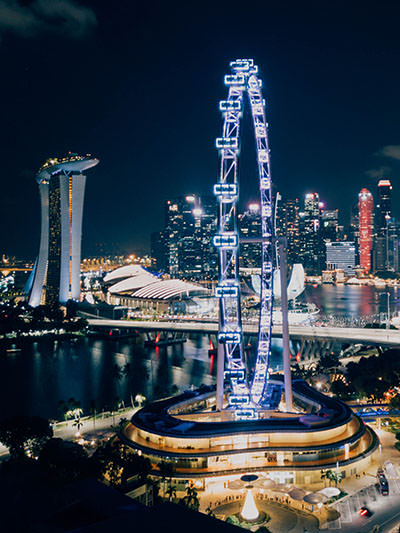 The night panorama of Singapore skyline, with Singapore Flyer, the largest Ferris wheel in Asia in the foreground; photo by Chuttersnap, Unsplash.