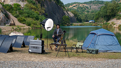 A guy camping by the lake with solar charging equipment by Zendure power station, Unsplash.