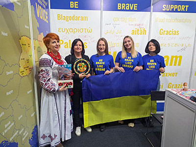 Ukraine tourism delegation posing at Place2Go tourism fair in Zagreb with their national flag (from left to right): Marina Antonyuk, president of the Association of incoming tour operators of Ukraine, Damjana Domanovac, director of Place2Go, Natalia Vasylenko, head of tourism development department at State Agency for Tourism Development, Liza Konoplova, manager of international cooperation & partnerships at the agency, and Jana Terlecka, from the Office for Preservation of Historical Environment at Lviv City Council.