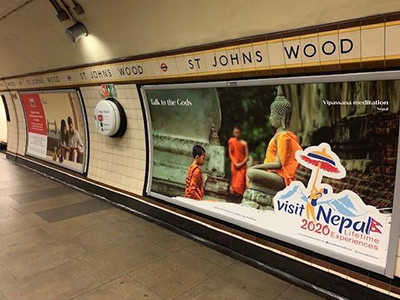 Visit Nepal 2020 tourism marketing campaign promoted with a banner in London underground, showing Theravada monks from Thailand; photo by Jagan Karki.