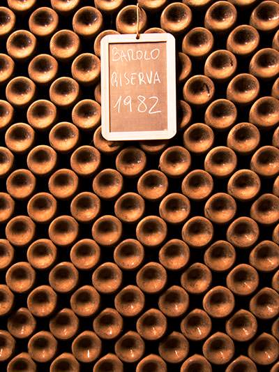 Bottoms of wine bottles stored horizontally, with label "Barolo Riserva 1982", at Borgogno winery, one of the top wineries in Italy; photo by MSR.