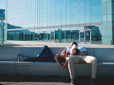Young couple resting during the siesta on a public square in Barcelona, Spain; photo by Anthony Mapp, Unsplash.