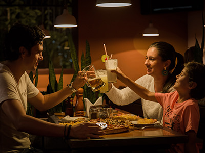 A family eating a meal together, and raising a toast with drinks; photo by Pablo Merchan Montes, Unsplash.