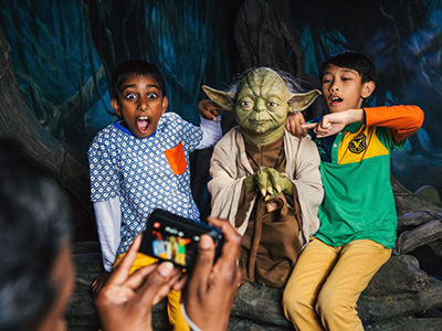 Boys taking a photograph with Master Yoda wax figure at Madam Tussauds London museum; photo by Viator.
