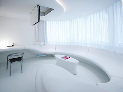 Curved sofa in a futuristic white room designed by Zaha Hadid, at Puerta America Hotel in Madrid, Spain.