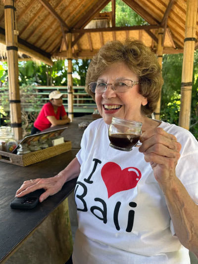 Sandy Hazelip, with a T-shirt "I love Bali", drinking a coffee on the Indonesian island of gods; photo by Ellie Hamby.