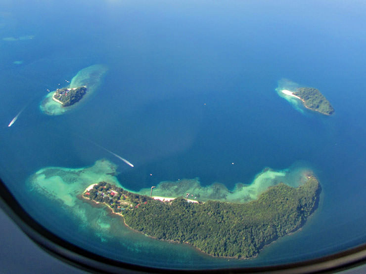 Seen from the plane window, Manukan, Mamutik and Sulug are three Malaysian islands that together look like a smiley face; photo by Jason Thien.