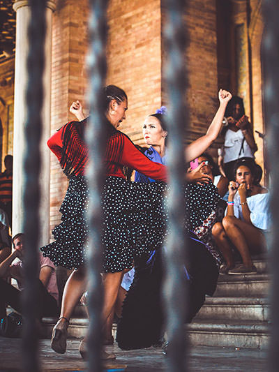 Women dancing in the street of Sevilla, Spain; photo by Stephan Valentin, Unsplash.